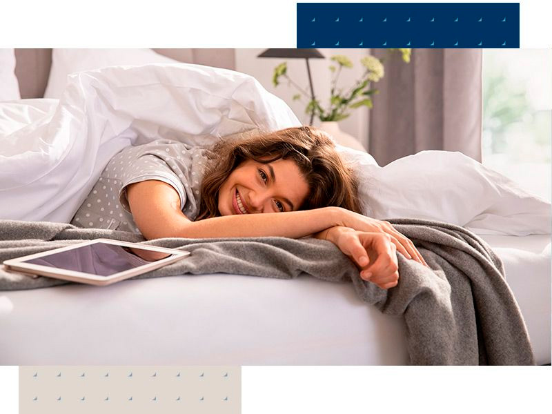 Frau liegt seitlich auf Boxspringbett